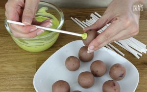 Buttermilch Cake Pops Rezept: Stiele mit Hilfe der geschmolzenen Candy Melts anbringen