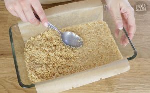 No Bake Cheesecake Bars Rezept: Keksemasse in der Auflaufform verteilen