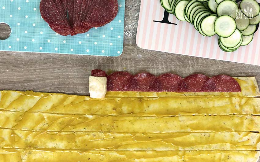 Herzhafte Brotrosen Rezept: Teigstreifen mit Salami belegen