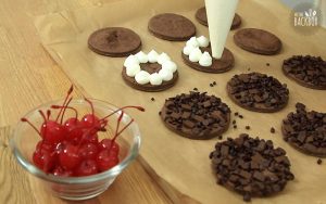 Schwarzwälder Kirsch Taler Rezept: Auf die unteren Taler am Rand kleine Sahne-Tupfen auftragen