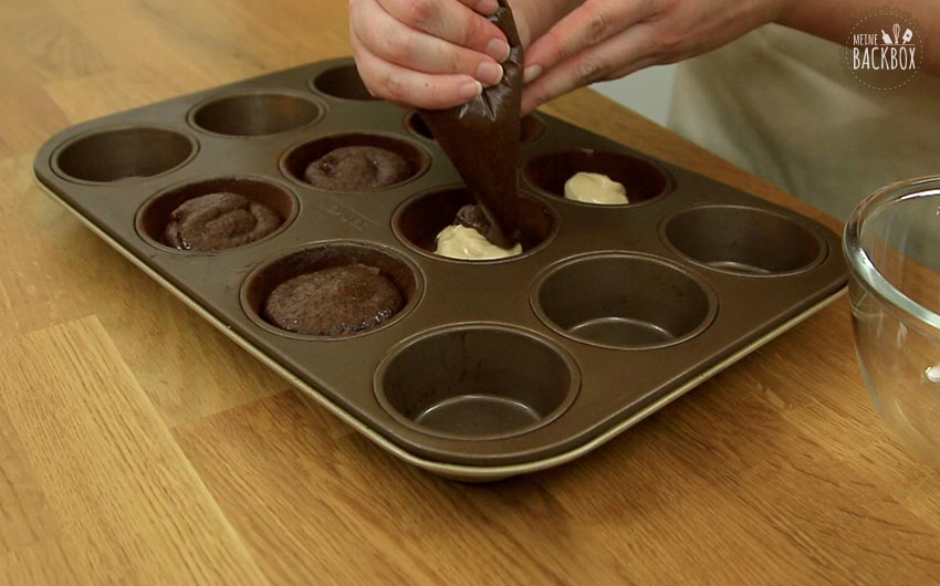 Mandel Lava Cakes Rezept: restlichen Teig auf Mandelcreme geben