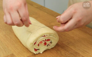 Erdbeer Puddingschnecken: Rolle mit einem Faden in Stücke schneiden