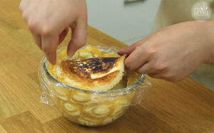 Pancake-Boden auf Mango-Vanille Charlotte legen