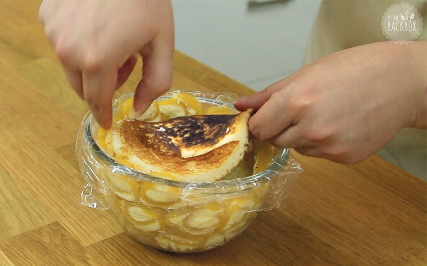 Pancake-Boden auf Mango-Vanille Charlotte legen