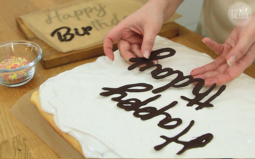 Sekt-Schmandkuchen: Schriftzug auf den Kuchen auflegen