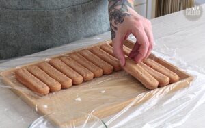 Erdbeer Tiramisurolle Rezept: Löffelbiskuits in zwei Reihen legen